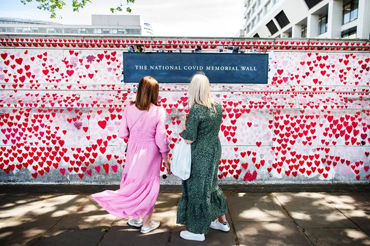 Ηνωμένο Βασίλειο, 6 Μαΐου 2022: Δύο γυναίκες στέκονται μπροστά από το Εθνικό Μνημείο COVID στο Λονδίνο, κοιτάζοντας τις καρδιές που έχουν ζωγραφιστεί στη μνήμη όσων πέθαναν από την COVID-19. Πάνω από 150.000 χειροποίητες καρδιές αποτελούν τραγική μαρτυρία για τις ζωές που χάθηκαν από αυτόν τον ιό. ©WHO /Sanne De Wilde - NOOR