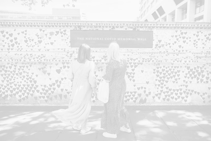 Ηνωμένο Βασίλειο, 6 Μαΐου 2022: Δύο γυναίκες στέκονται μπροστά από το Εθνικό Μνημείο COVID στο Λονδίνο, κοιτάζοντας τις καρδιές που έχουν ζωγραφιστεί στη μνήμη όσων πέθαναν από την COVID-19. Πάνω από 150.000 χειροποίητες καρδιές αποτελούν τραγική μαρτυρία για τις ζωές που χάθηκαν από αυτόν τον ιό. ©WHO /Sanne De Wilde - NOOR