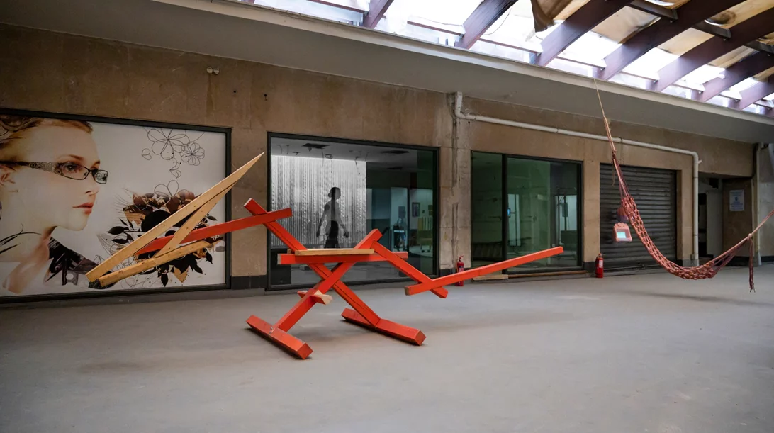 "Το τραπέζι ανάμεσα στα κρεβάτια" είναι ένα καλλιτεχνικό πείραμα πάνω στην ιδέα της συλλογικότητας σε μια "άγνωστη" στοά της Αθήνας