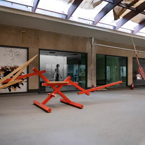 "Το τραπέζι ανάμεσα στα κρεβάτια" είναι ένα καλλιτεχνικό πείραμα πάνω στην ιδέα της συλλογικότητας σε μια "άγνωστη" στοά της Αθήνας